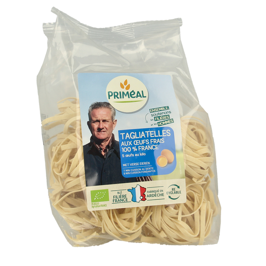 Primeal bio tagliatelle pasta with fresh eggs, 250g, showcasing uncooked pasta strands in a natural setting.