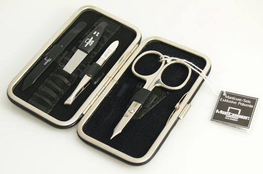 Malteser manicure set with four black lacquer and velvet leather steel tools, compact and stylish for grooming.