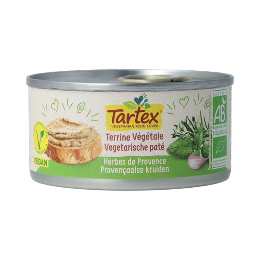 Tartex Provencal herbs organic pate spread on bread, showing creamy texture and fresh herbs in a jar.