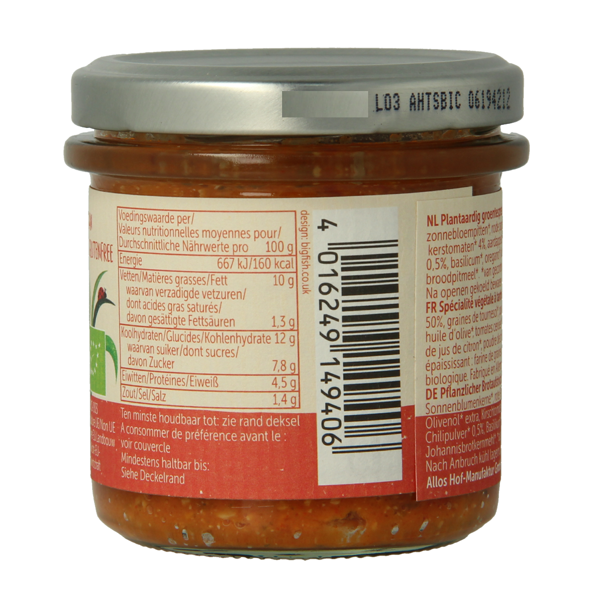 Allos Farm organic spicy tomato spread on bread, close-up of the vegetable-topped spread in a jar.