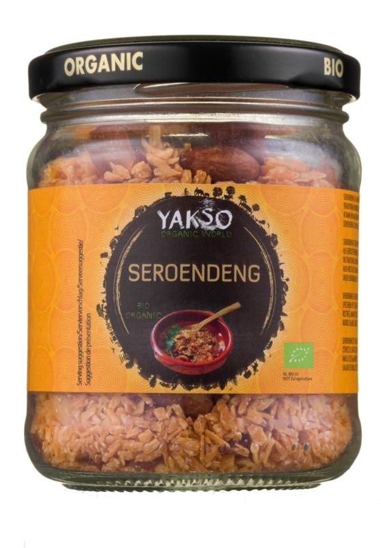 Yakso Seroendeng bio, 85g, in a clear container showing the crunchy, golden coconut and spice mixture used as a sauce or flavoring.