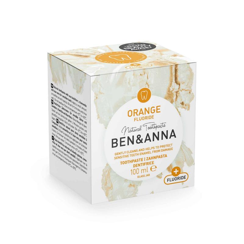 Ben & Anna orange fluoride toothpaste in 100g tube, natural oral care product with bright orange packaging and fresh citrus scent.