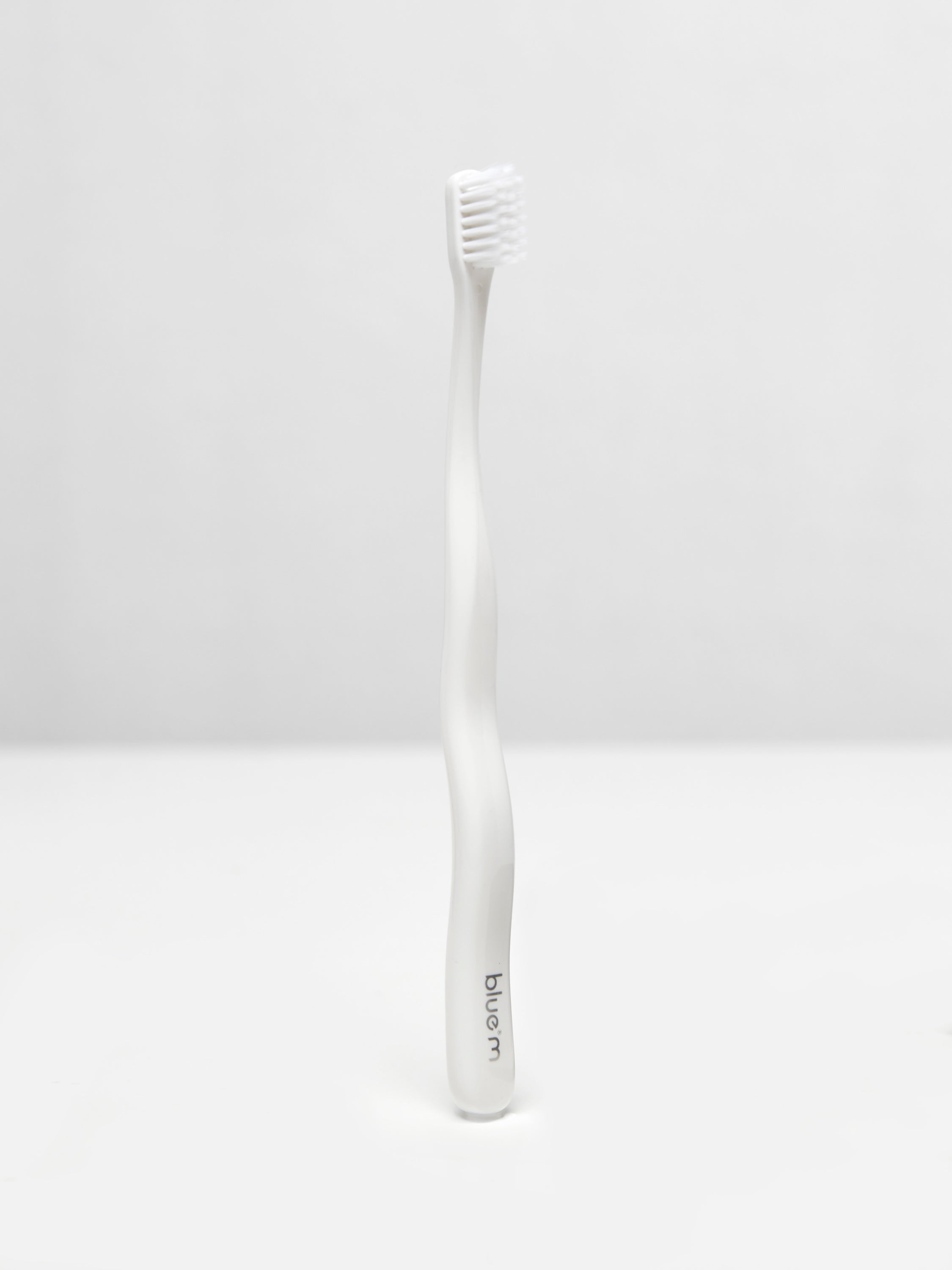 Bluem post-surgical toothbrush in white, designed for gentle oral care, with soft bristles for sensitive teeth.