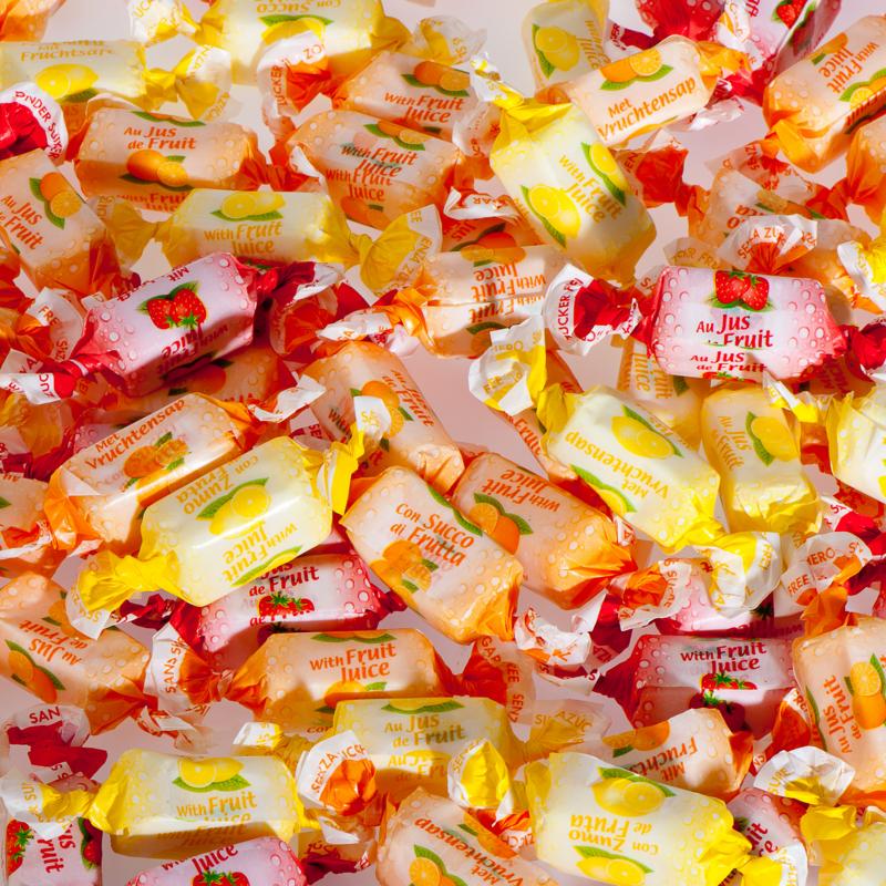 De Bron fruit toffee snoepgoed, suikervrij, 1 kilogram, with colorful fruit-flavored toffee pieces on a white background.