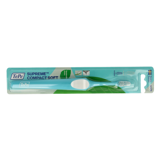 TePe Supreme Compact Soft toothbrush with pink handle, designed for gentle oral cleaning, shown in close-up.