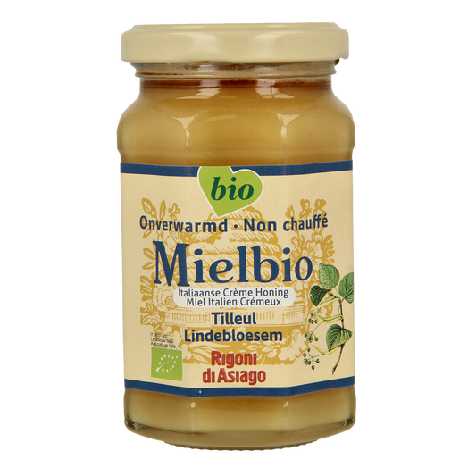Jar of Mielbio Lindebloesem organic honey cream with a golden honey color and label, placed on a wooden surface.