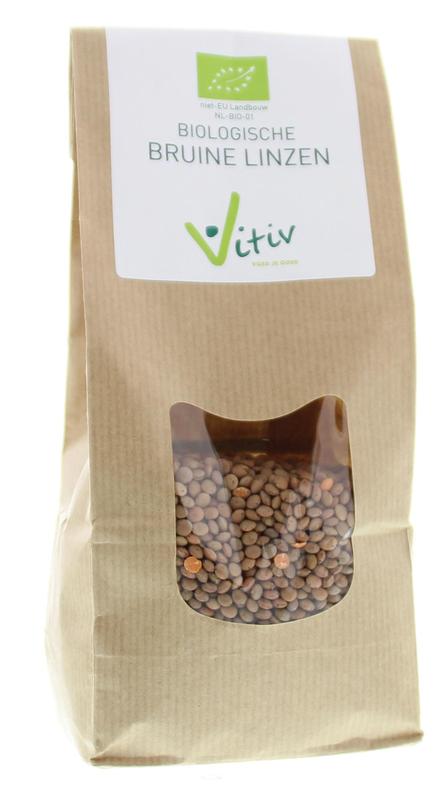 Organic Vitiv brown lentils in a 500g package, displayed alongside fresh vegetables and potatoes on a grocery store shelf.