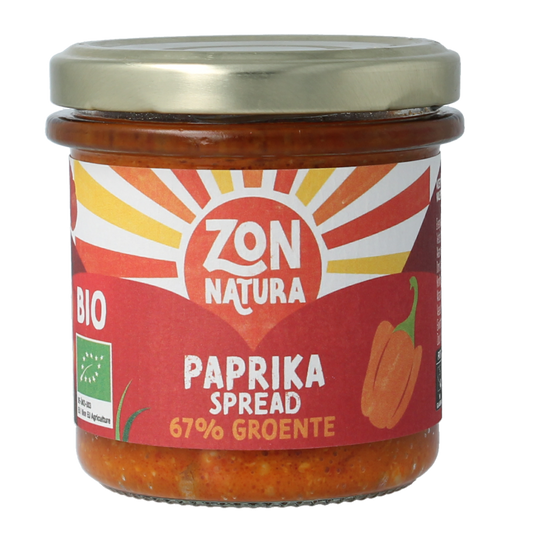 Zonnatura Groentespread paprika bio on bread, showcasing the vibrant orange spread in a jar with a spoon.
