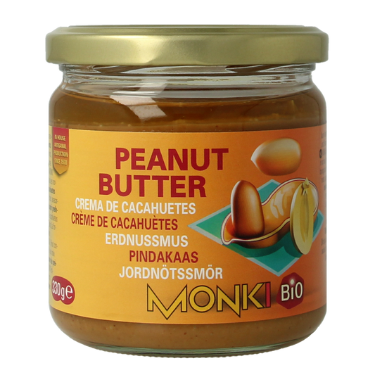 Monki bio unsalted peanut butter spread on bread, 330g jar, natural and creamy, ideal for sandwiches and snacks.