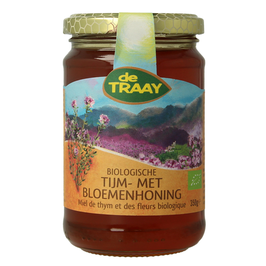 De Traay biologische tijmhoning met bloemenhoning in 350g jar, showing golden honey with floral elements on the label.