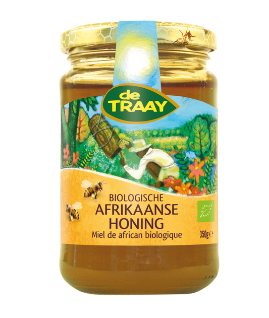 Jar of de Traay organic African honey, 350g, with golden honey visible inside and a label displaying the brand and product details.