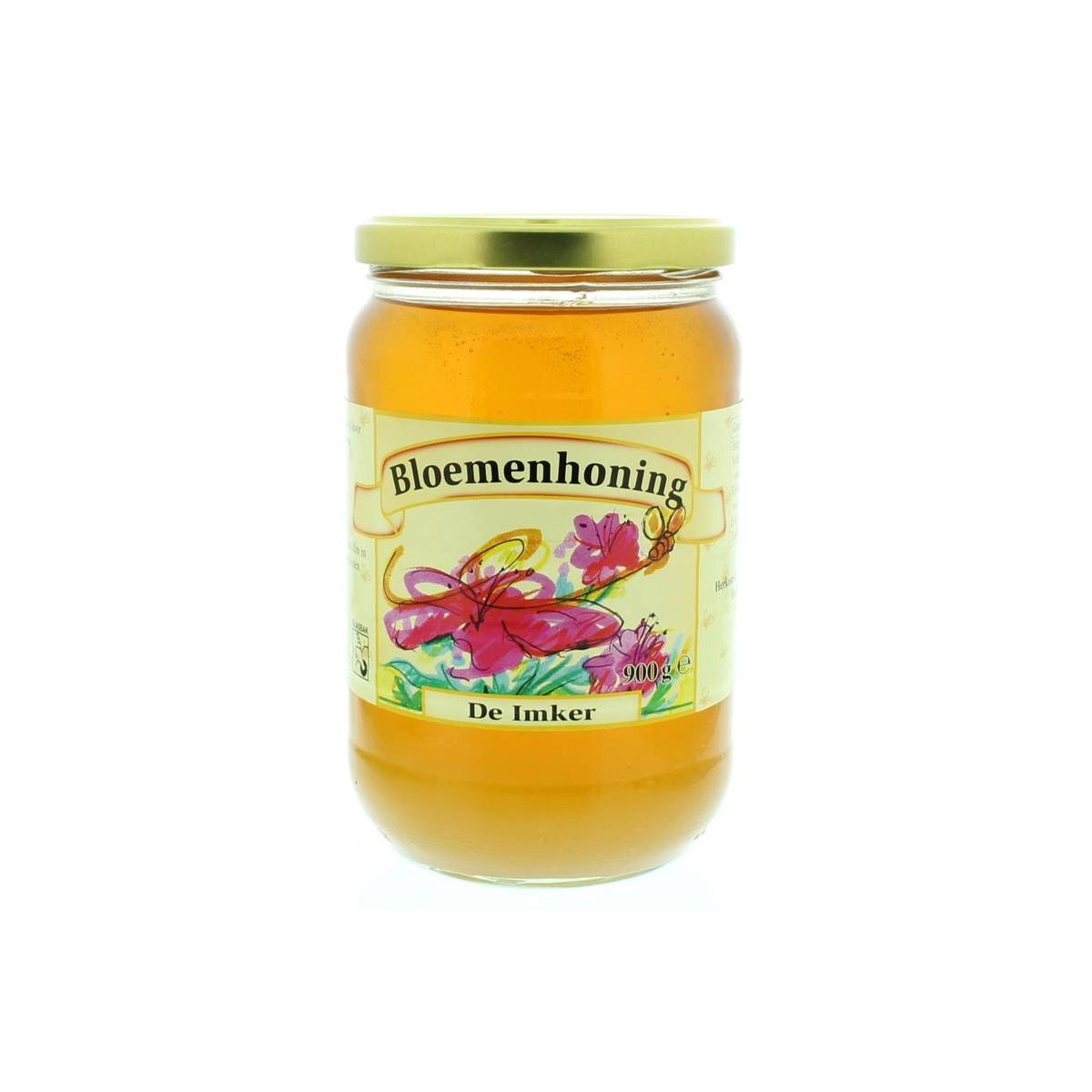 Liquid De Imker flowers honey in a 900g jar, showing golden honey flowing from the jar with a honey dipper.