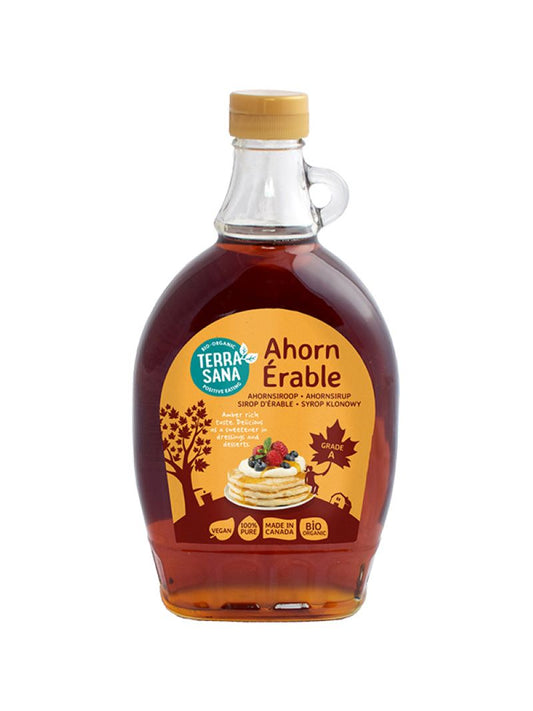 Glass bottle of TerraSana Ahornsiroop Graad A organic maple syrup, 500ml, in a natural setting.
