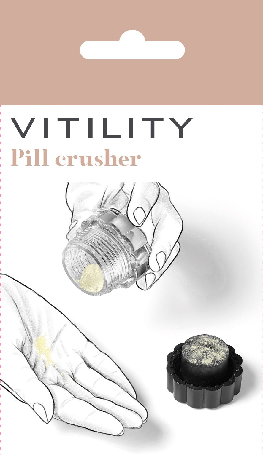 Vitility tablet crusher instrument for medication, shown in white with textured grip, used for splitting or crushing tablets.
