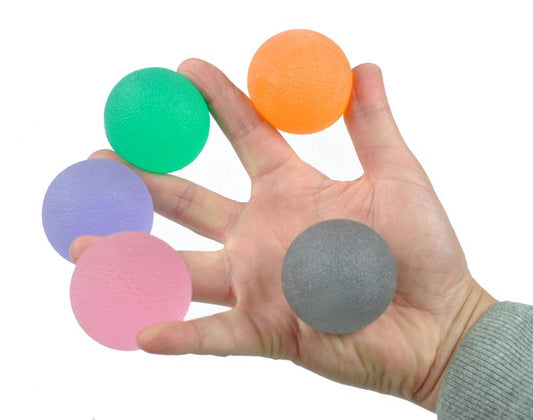 Able 2 Handtrainer gelbal medium groen for exercise and therapy, showing a green gel-filled hand grip in a natural setting.