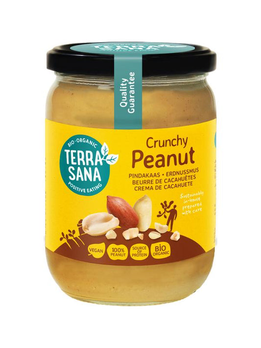 Crunchy organic TerraSana Pindakaas peanut butter spread on bread, 500g jar, ideal for sandwiches and toast.