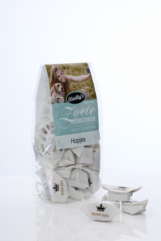 Kindly's Hollandse hopjes snoepgoed in 130g package, showing golden caramel candies with a smooth, glossy texture.