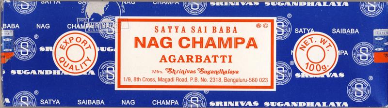 Nag Champa brand incense sticks, agarbatti, in a 100 gram package, displayed in a natural setting with burning incense.