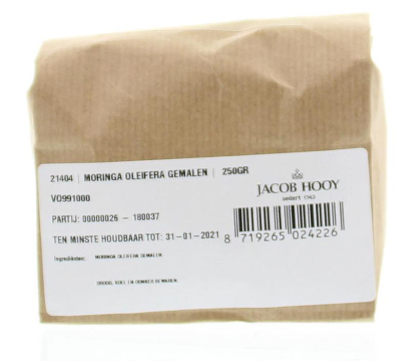 Ground Jacob Hooy Moringa oleifera in a 250g jar, part of herbs, spices, and meal mixes, with fresh green leaves visible.