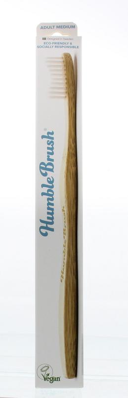 The Humble Co bamboo medium toothbrush with white bristles, eco-friendly handle, designed for oral hygiene.