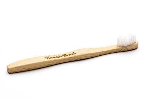 The Humble Co bamboo kids toothbrush with soft bristles, designed for children, featuring a natural bamboo handle.