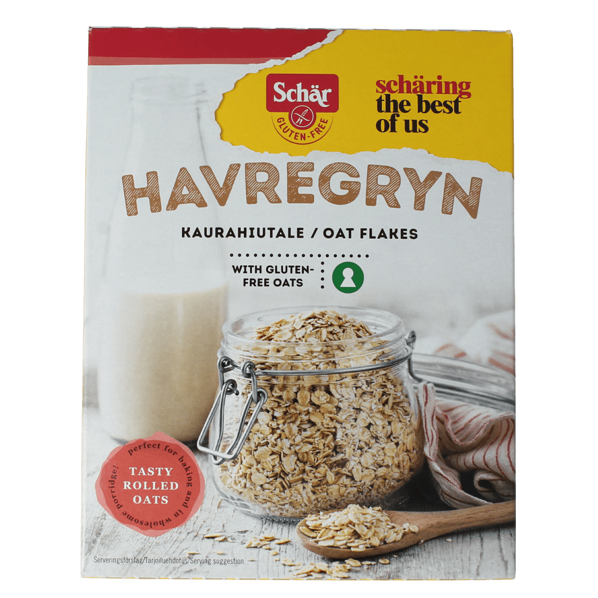 Schar glutenvrije havervlokken ontbijtgranen in een witte kom, met een lepel en een glas melk op de achtergrond.